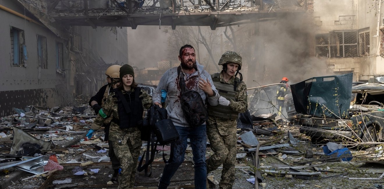 A person is helped by emergency personnel after an attack in a commercial area of Kharkiv 