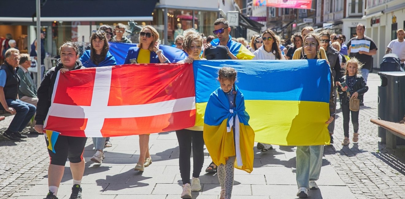 Marchers hold Ukrainian and Danish flags