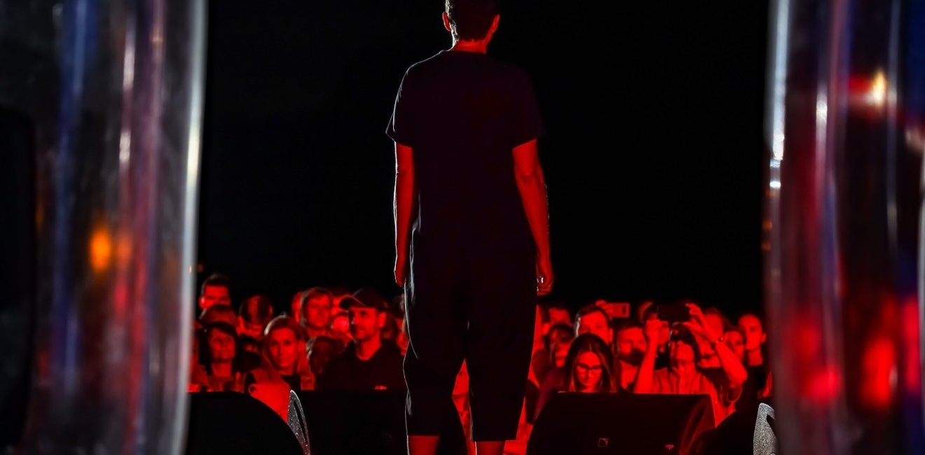 Image of person on stage with audience in the background 