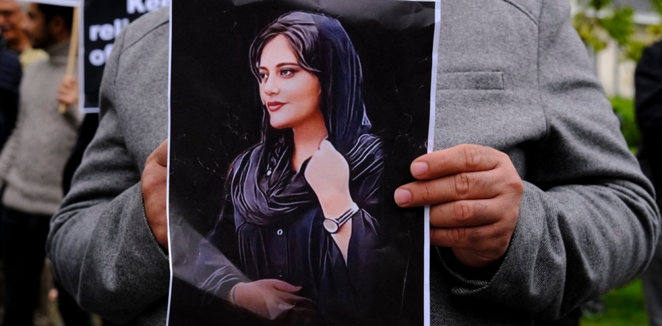 Protester holding photo of Mahsa Amini