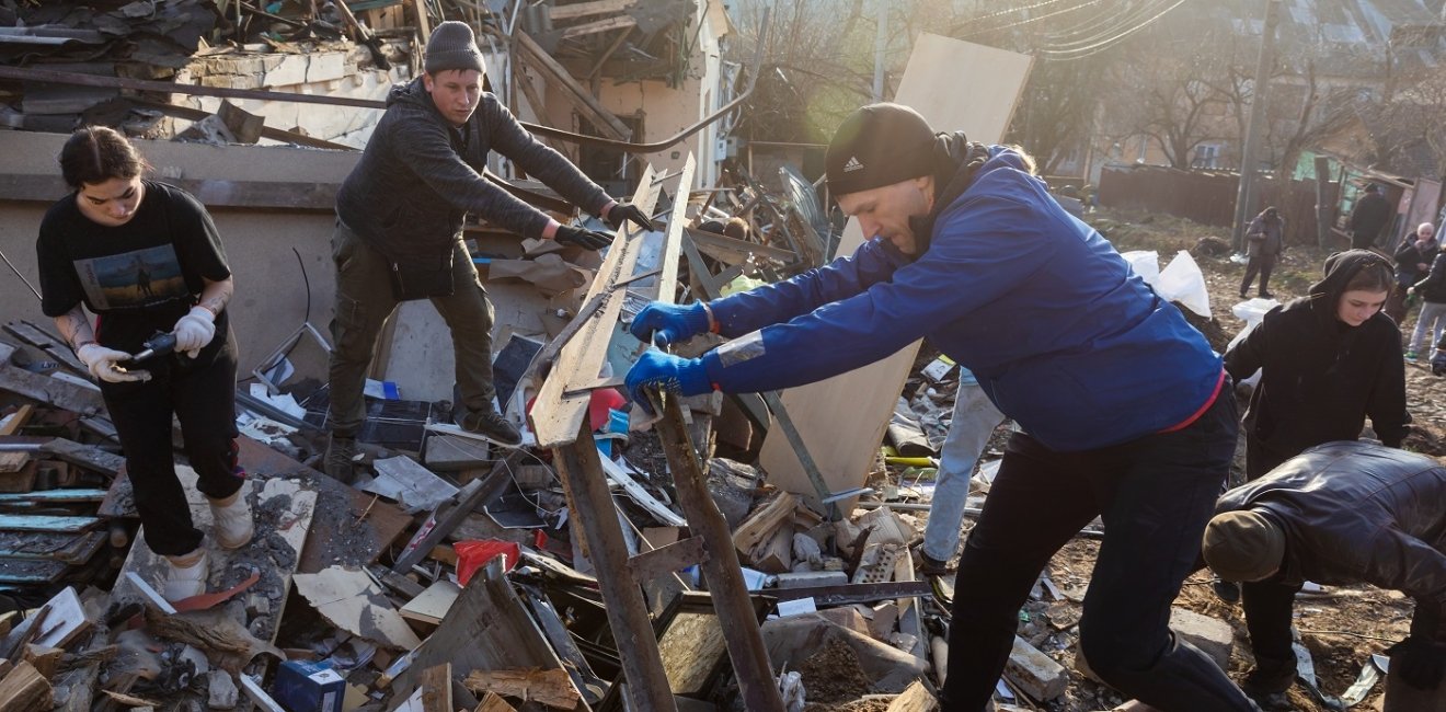 Volunteers clear and dismantle debris at the site of a Russian missile attack on December 31, 2022