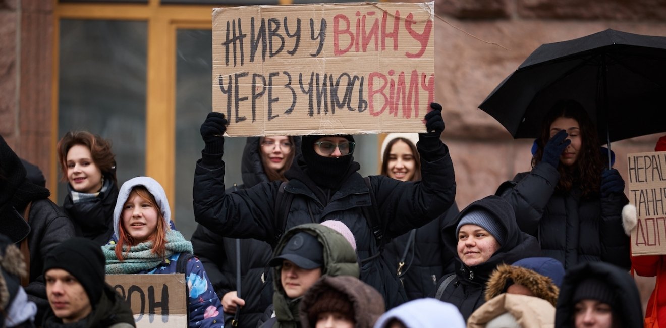 Young Ukrainian activists show a banner "I Live In A War Because of Someone's New Villa" on a protest against corruption in Ukraine