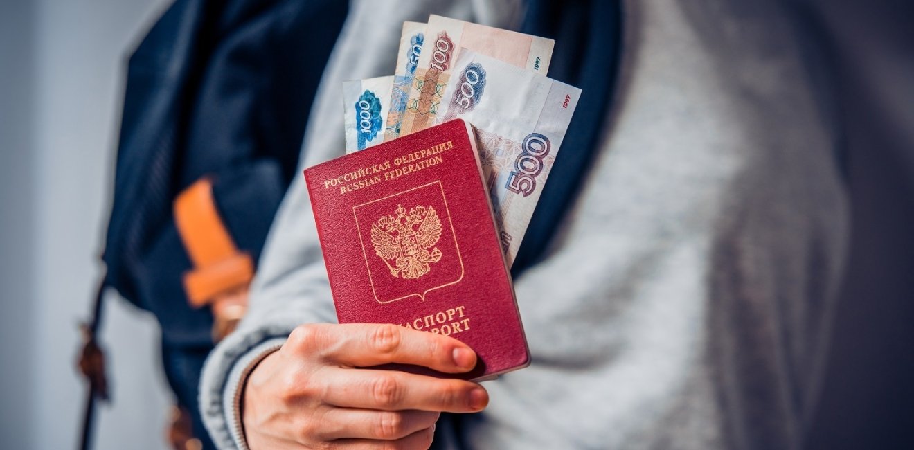 Tourist holds Russian passport and Russian roubles