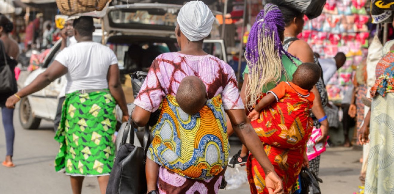 Little babies carried by their mothers at a market in West Africa.