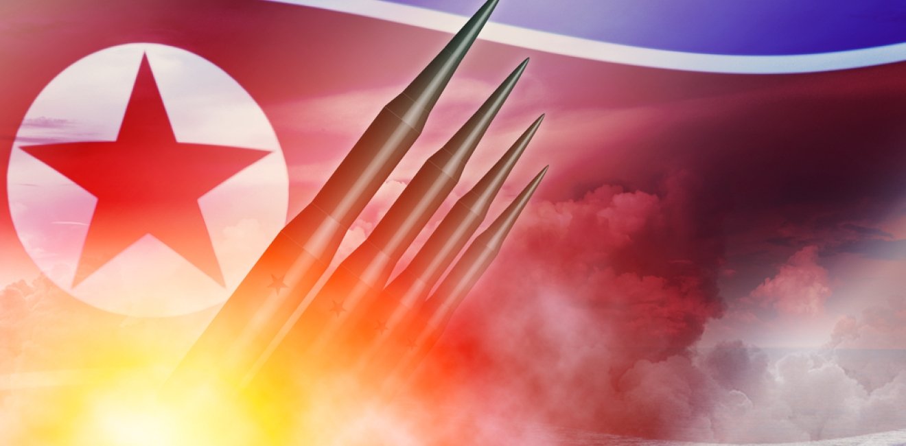 Missiles being launched over a North Korean flag