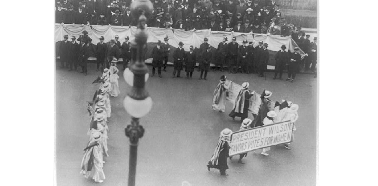 Suffragettes parading with banner "President Wilson favors votes for women". N.Y.C. , ca. 1916. Photograph. https://www.loc.gov/item/2001704196/.