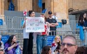 Protesters at Georgian parliament building in Tbilisi with flags and placards