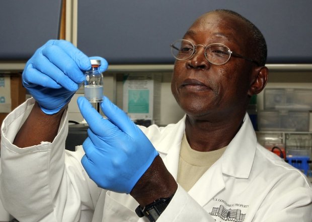 Biochemist looking at vial