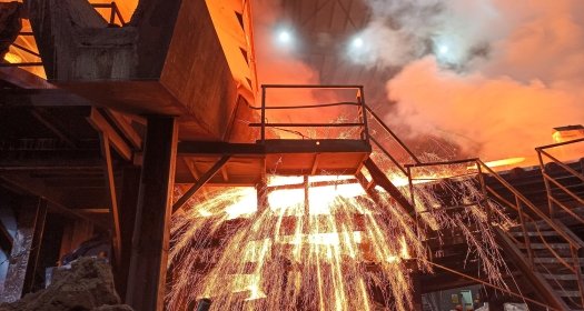 Sparks fly from a production smelter furnace.