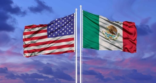 U.S. and Mexican flags at sunset