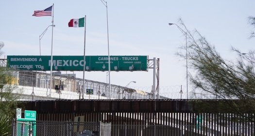 View of the U.S.-Mexico Border Wall with the Mexico border checkpoint on the Bridge of the Americas International Bridge in the background