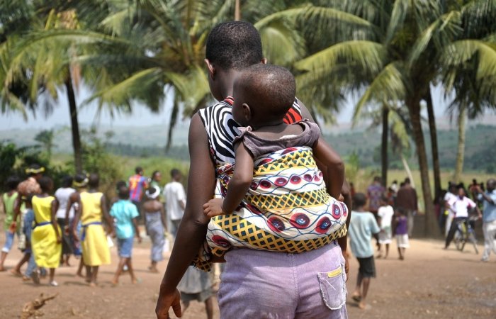 Ghana mother and child visit water pump provided by USAID