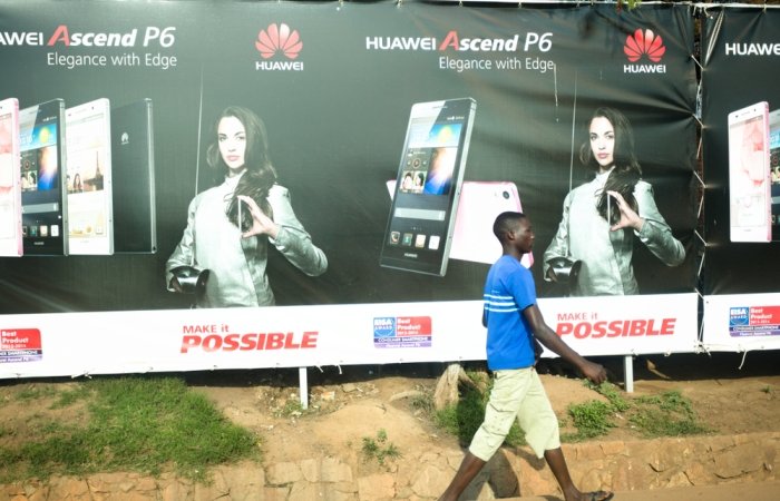 Kampala Uganda on January 23, 2018: people walking past mobile phone advertisement