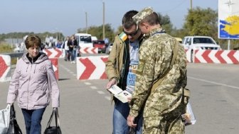 Border guard checking traveler’s passport at the border crossing point Kalanchak. September 20, 2017. Khersonskaya oblast, Ukraine. Source: Shutterstock.