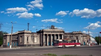 Old soviet red trolleybus with abandoned building of cinema "Metallurg". Soviet stalin architecture. Alchevsk, Luhansk region, Ukraine. Source: Shutterstock