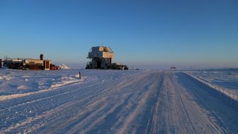 Snow road with a substructure of the oil work over rig and a distant view of the drilling rig at an oilfield in the tundra in winter. Source: Shutterstock