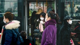 People riding a train in Chengdu, China wearing masks.