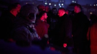 Group of men standing in a cemetery at night