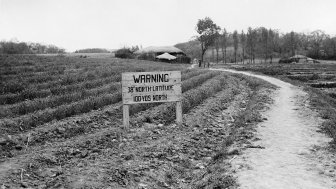 Sign reading, "Warning, 38th degree North Latitude 100 yards North".