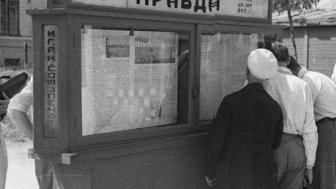 Image: People reading 'Pravda' newspaper on city street in Moscow