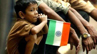 A young Indian boy with a flag from his country.