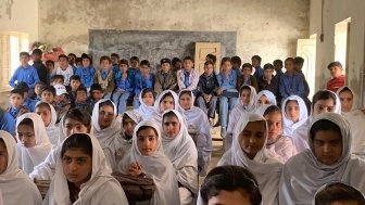 Pakistani children packed into an overcrowded schoolroom.