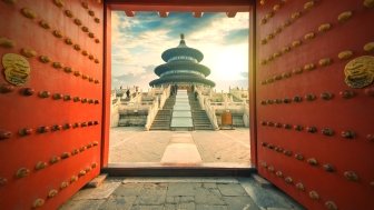 A view of a Chinese temple through a red door