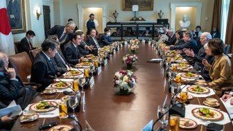 A group of delegates sits around an oval table.