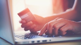 Person making a credit card purchase with computer