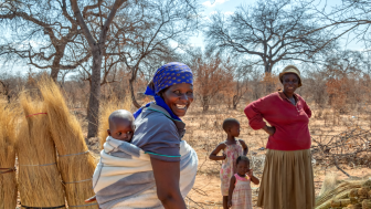 african woman carry child in the back in a traditional way in a blanket