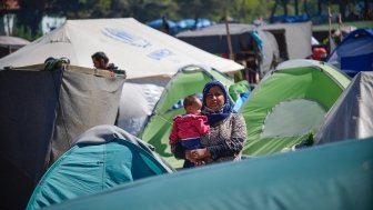 Woman with a baby in transit refugee/migrant camp at the Greek-North Macedonian border. 