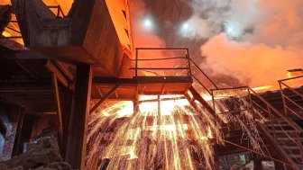 Sparks fly from a production smelter furnace.