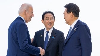 President Biden, Prime Minister Kishida, and President Yoon speaking casually at an event.