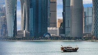 Boat in the water in front of large modern highrises