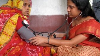 A woman health worker from a charity visited a house in a village to check the blood pressure of a pregnant mother as part of an antenatal checkup, Diamond Harbour, West Bengal.