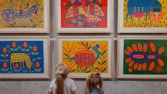 Two girls at an exhibition of paintings by Maria Prymachenko. 