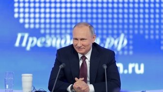 Image of Vladimir Putin smiling while taking questions