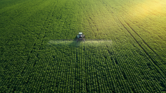 Aerial view of a tractor fertilizing a field