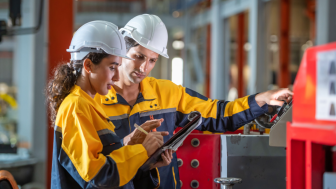 Two factory employees work together onsite