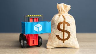 Forklift lifts a shipping container next to a bag of money