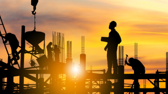 Silhouette of construction workers on site