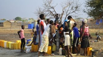 Juba, South Sudan, February 2017. People with yellow jerrycans waiting for water at a borehole site. Salesian camp for internally displaced persons (IDPs). Captured during civil war.