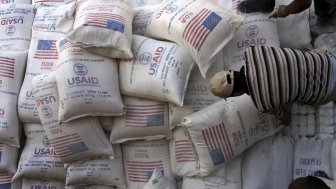 In this June 4, 2008 file photo, Palestinians unload bags of flour donated by the United States Agency for International Development, USAID, at a depot in the West Bank village of Anin near Jenin. AP Photo/Mohammed Ballas.