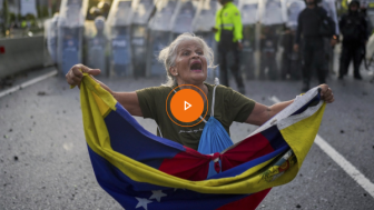 Video_Consuelo Marquez holds a Venezuelan flag in front of police blocking demonstrations against the official election results declaring President Nicolas Maduro's reelection, the day after the vote in Caracas, Venezuela, Monday, July 29, 2024. 