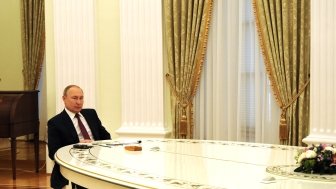 Vladimir putin alone at a long table