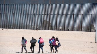 A group of migrants walks near the U.S. border.