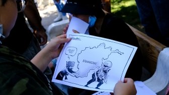 A protester holds a placard during a demonstration of members of the Afghan community outside the US embassy in Athens after the Taliban swept to power in Afghanistan on August 28, 2021