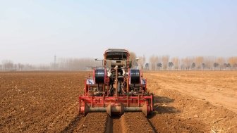 Farmer driving agricultural machinery