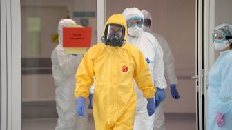 In a sign that the Kremlin's attitude toward the virus hazard is changing, President Vladimir Putin visited a hospital for infectious disease and changed into a hazmat suit