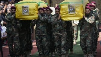 Hezbollah members carry the coffins of two of their comrades during a funeral procession in the southern suburbs of Beirut, Thursday, Sept. 19, 2024. (AP Photo/Hussein Malla)